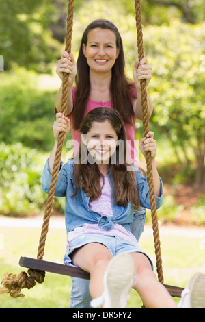 Felice madre figlia di spinta su swing Foto Stock