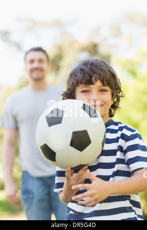 Padre e figlio a giocare a calcio in posizione di parcheggio Foto Stock