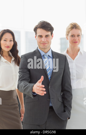 Imprenditore raggiungendo fuori mano davanti al suo compagno di squadra Foto Stock