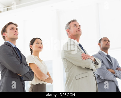 Grave del team di business con le braccia incrociate cercando Foto Stock
