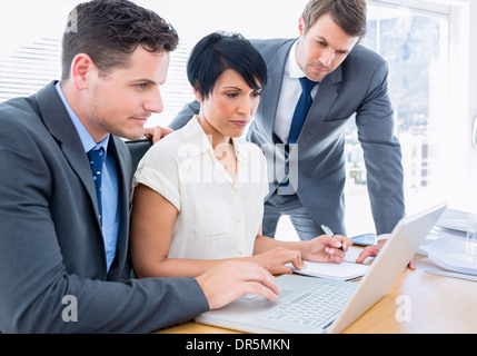 I colleghi utilizzando il portatile in ufficio Foto Stock