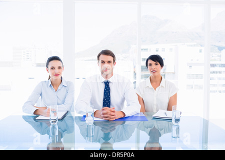 Elegantemente vestito giovani dirigenti seduti alla scrivania Foto Stock