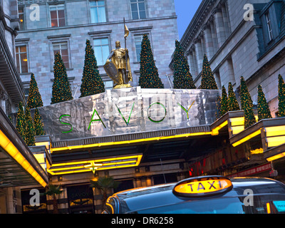 SAVOY HOTEL & TAXI Vista esterna del lussuoso ingresso del Savoy Hotel a cinque stelle a Natale con Londra taxi a noleggio in primo piano The Strand London Foto Stock