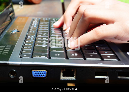 Mani femminili su una tastiera portatile Foto Stock