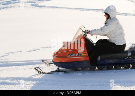 Una donna nel suo inizio 30s godendo di un tratto in snowmobile dopo una nevicata fresca in Quebec, Canada. Foto Stock