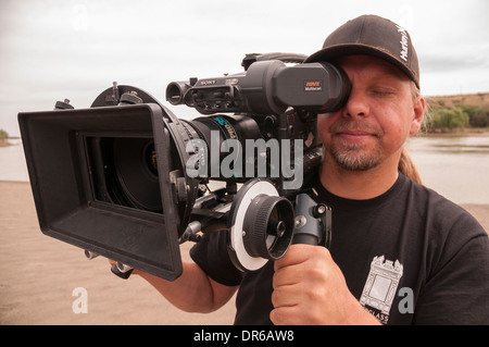 Cameraman consente di girare video in HD con un primo obiettivo in un polveroso e poveri città in Sud Africa settentrionale di Cape. Foto Stock