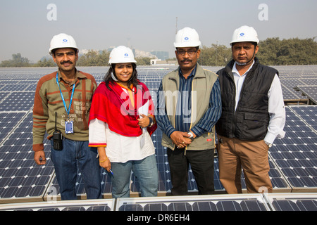 Lavoratori a 1 MW di energia solare stazione gestito da Tata power sul tetto di una società di elettricità di Delhi, India. Foto Stock