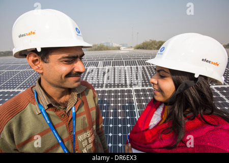 Lavoratori a 1 MW di energia solare stazione gestito da Tata power sul tetto di una società di elettricità di Delhi, India. Foto Stock