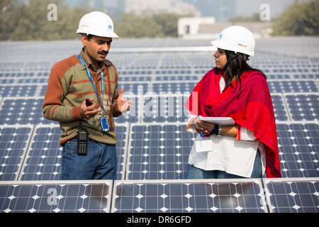 Lavoratori a 1 MW di energia solare stazione gestito da Tata power sul tetto di una società di elettricità di Delhi, India. Foto Stock