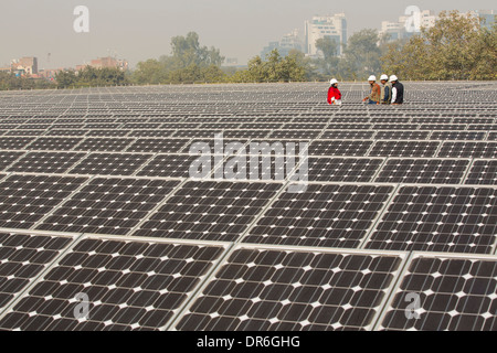 Lavoratori a 1 MW di energia solare stazione gestito da Tata power sul tetto di una società di elettricità di Delhi, India. Foto Stock