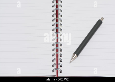 Un rivestito Rilegato a spirale Notebook aperto con una penna Foto Stock