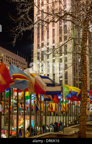 Bandiere internazionali circondano la pista di pattinaggio sul ghiaccio al Rockefeller Center, Manhattan, New York City, Stati Uniti d'America Foto Stock