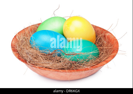 Multicolore di uova di Pasqua in un nido isolato su uno sfondo bianco Foto Stock