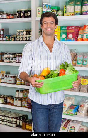 Uomo con cesto di verdura nel supermercato Foto Stock