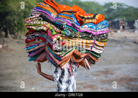 Un uomo che porta i tessuti in Sunderbans, un basso area del delta del Gange in India Orientale, che è molto vulnerabile a mare Foto Stock