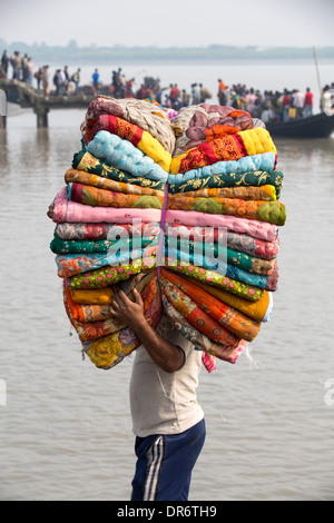 Un uomo che porta i tessuti in Sunderbans, un basso area del delta del Gange in India Orientale, che è molto vulnerabile a mare Foto Stock