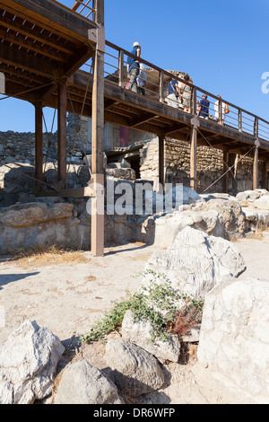 I turisti sulla passerella visitare l'antico palazzo di Cnosso a Creta, Grecia Foto Stock