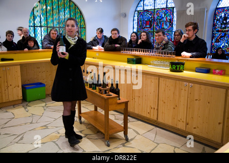 I turisti essendo servito di campioni di liquore Chartreuse al tourist negozio della fabbrica della distilleria della Chartreuse monaci. La Francia. Foto Stock