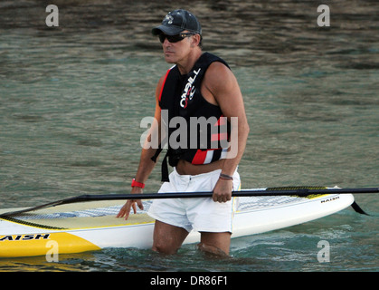 Il cantante Bruce Springsteen facendo paddlesurf su una spiaggia in vacanza a Maiorca nel 2013. Foto Stock