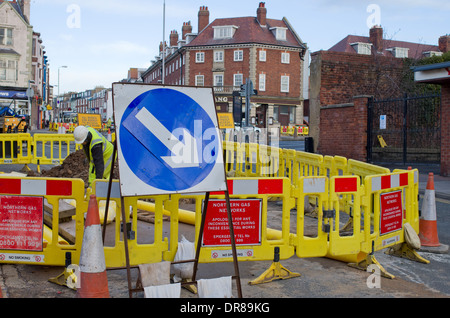 Uomo che lavora nel foro della strada strada asfaltata. Scarborough North Yorkshire Regno Unito Foto Stock