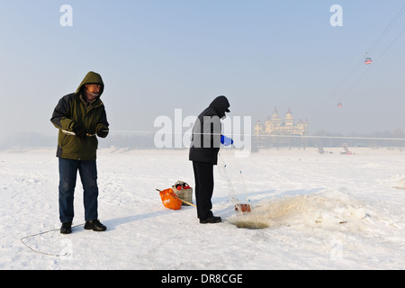 Pesca sul ghiaccio sulla congelati Songhua river . Harbin, Heilongjiang Provincia , Cina Foto Stock