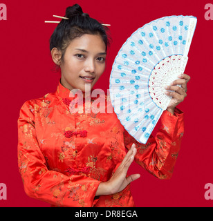 Ragazza asiatica con un ventilatore Foto Stock