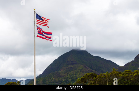 L'Hawaiian e bandierine americane volare alto nella parte anteriore delle montagne Koolau su Oahu, Hawaii Foto Stock