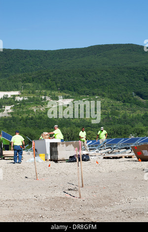 Lavoratori tra i pannelli solari vicino al completamento installazione in Adams, Massachusetts. Foto Stock