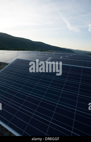 Il sole tramonta su un campo di pannelli solari vicino al completamento installazione in Adams, Massachusetts. Foto Stock