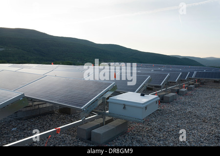 Il sole tramonta su un campo di pannelli solari vicino al completamento installazione in Adams, Massachusetts. Foto Stock