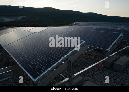 Il sole tramonta su un campo di pannelli solari vicino al completamento installazione in Adams, Massachusetts. Foto Stock