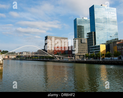 Una vista di Santiago Calatrava-progettato Zubizuri passerella, il fiume Nervion e nuovi grattacieli di Bilbao, Spagna. Foto Stock