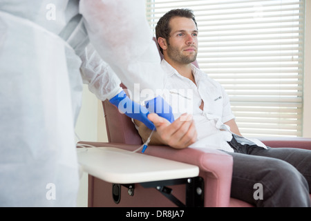 Paziente che riceve il trattamento per via endovenosa in sala di chemo Foto Stock