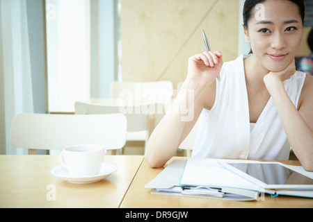 Una donna con una camicia bianca a lavorare Foto Stock