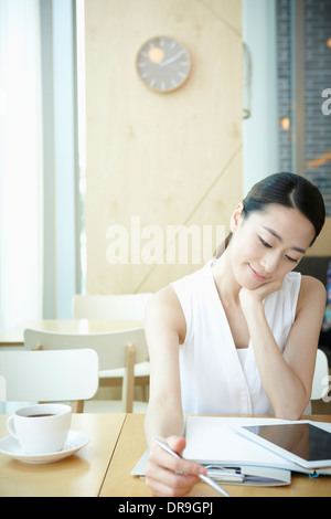 Una donna con una camicia bianca a lavorare Foto Stock