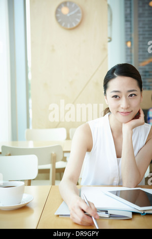 Una donna con una camicia bianca a lavorare Foto Stock