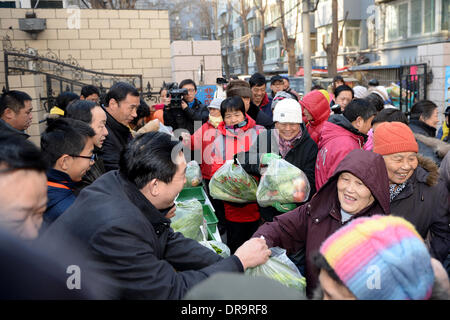 Pechino, Cina. Il 22 gennaio, 2014. I residenti locali ricevono vegetali per libero a una comunità di Pechino, capitale della Cina, 22 gennaio 2014. Al fine di garantire una calda festa della primavera per famiglie con difficoltà, per un totale di 32 tonnellate di verdure sono state date ai bisognosi residenti gratuitamente in Xi'cheng distretto di Pechino mercoledì. © Li Xin/Xinhua/Alamy Live News Foto Stock
