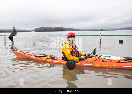 Kayakers nelle acque di esondazione su strada a Storth sul Kent Estuary in Cumbria, Regno Unito, durante il mese di gennaio 2014 tempeste Foto Stock