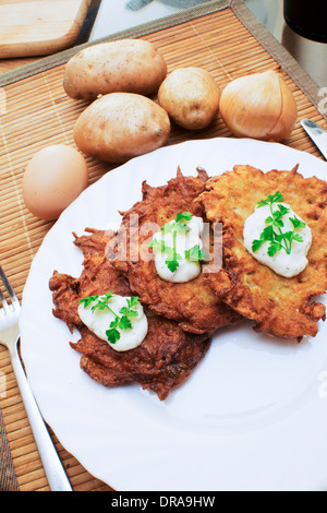 Frittelle di patate con panna acida e prezzemolo Foto Stock