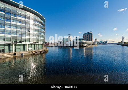Il Lowry arts center, attraverso l'acqua da Media City con un cielo blu. Salford Quays, Manchester, Regno Unito Foto Stock