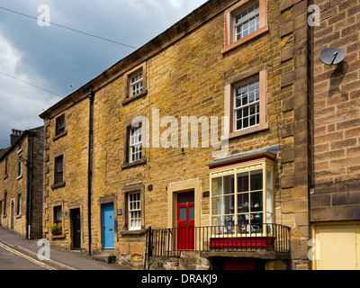 Tradizionali in pietra costruito case terrazzate sul pendio di una collina in Bakewell Derbyshire Dales Parco Nazionale di Peak District Inghilterra REGNO UNITO Foto Stock