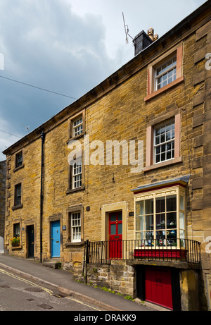 Tradizionali in pietra costruito case terrazzate sul pendio di una collina in Bakewell Derbyshire Dales Parco Nazionale di Peak District Inghilterra REGNO UNITO Foto Stock