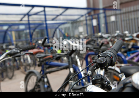 Biciclette parcheggiate in modo sicuro nel ciclo di sicura area di parcheggio al di fuori di una stazione ferroviaria in Inghilterra. Foto Stock