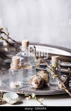 Frammento di Pasqua interno con po' di fiale di vetro, blossom ramo e uova di quaglia. Vedere serie Foto Stock