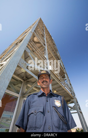 Una guardia di sicurezza al di sotto della torre di avvistamento di Asia il più grande popwer solare stazione, il Gujarat Parco Solare, in Gujarat, India Foto Stock