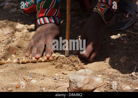 Maschio da Samburu tribù in un Samburu borgo fa fuoco con un bastone di tornitura Foto Stock