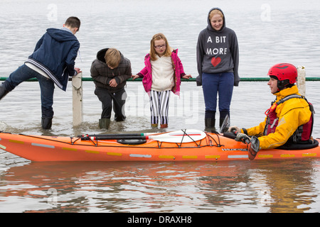 Kayakers nelle acque di esondazione su strada a Storth sul Kent Estuary in Cumbria, Regno Unito, durante il mese di gennaio 2014 storm Foto Stock