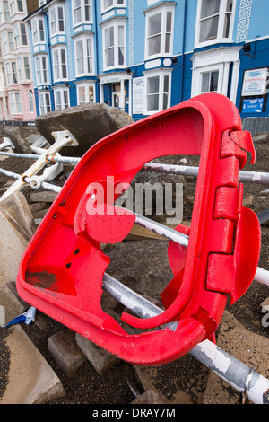 Dopo una settimana di alta marea, mareggiate e tempesta vigore venti, il lungomare di Aberystwyth in Galles è stato devastato, con milioni di £ 's di danni. Le onde che si infrangono punzonato un grande foro nella parete del mare ed è crollato Aberystwyth iconici, lungomare vittoriano rifugio, che ha resistito per oltre 100 anni. Questa foto è stata scattata mercoledì 8 gennaio, 2014, il giorno in cui il Consiglio ha cominciato a cercare di cancellare le migliaia di tonnellate di macerie spiaggia fuori di fronte al mare su strada. Foto Stock