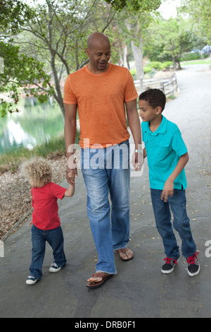 Padre con i bambini a piedi giù per un sentiero a Menlo Park Foto Stock