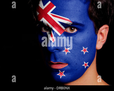 Bandiera della Nuova Zelanda dipinta su una faccia di un giovane uomo Foto Stock